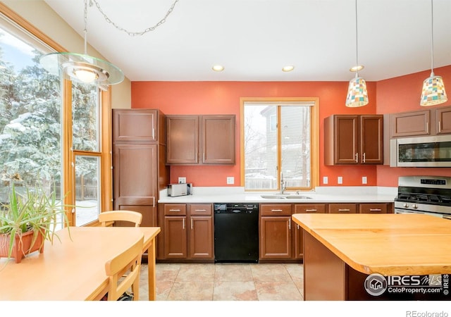 kitchen featuring butcher block counters, appliances with stainless steel finishes, light tile patterned floors, sink, and pendant lighting