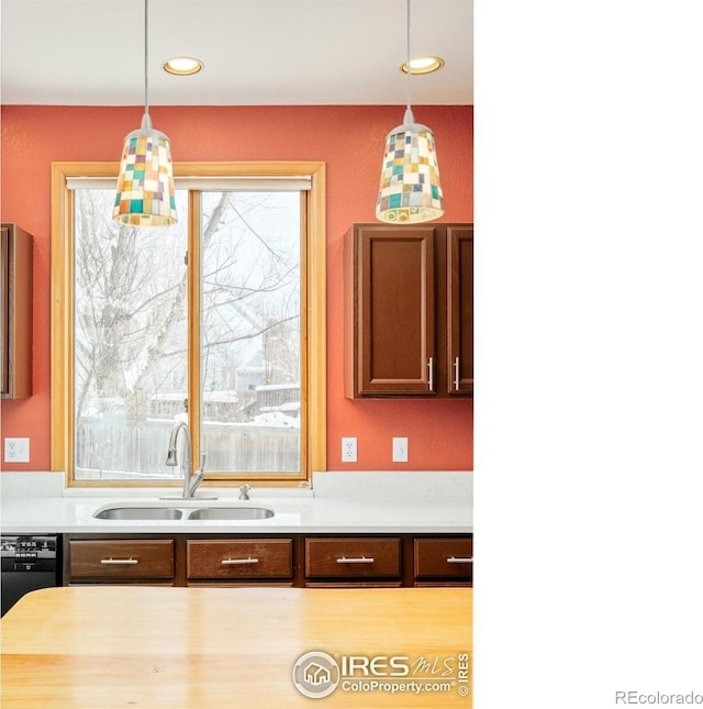 kitchen featuring decorative light fixtures, sink, and dishwasher