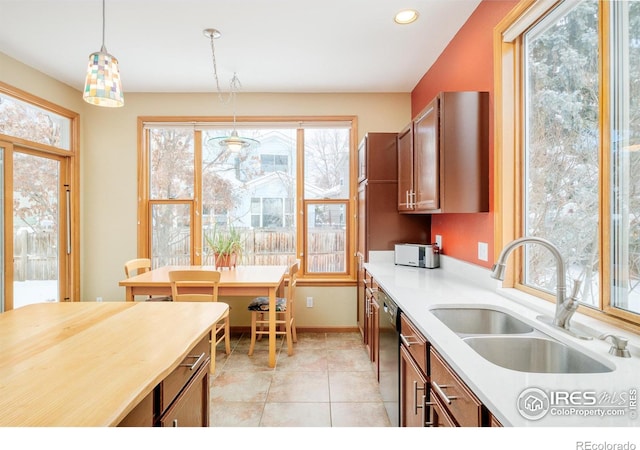 kitchen featuring sink, hanging light fixtures, dishwasher, and a wealth of natural light