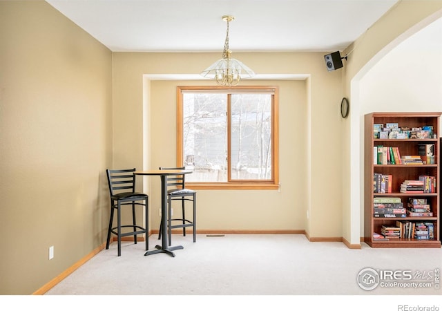 living area with carpet flooring and a notable chandelier