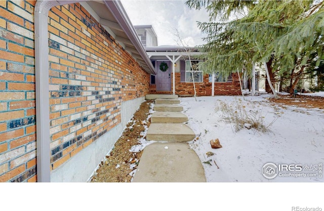 view of snow covered property entrance