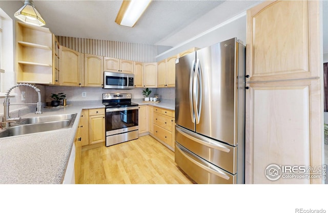 kitchen featuring light wood-type flooring, stainless steel appliances, sink, and light brown cabinets