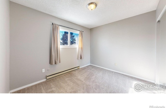 carpeted empty room with a baseboard heating unit and a textured ceiling