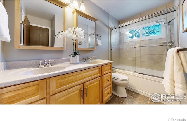 full bathroom with enclosed tub / shower combo, tile patterned floors, toilet, and vanity