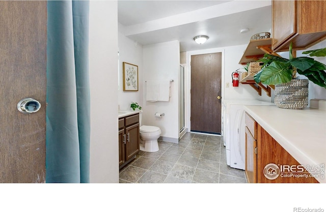 bathroom featuring vanity, toilet, and an enclosed shower