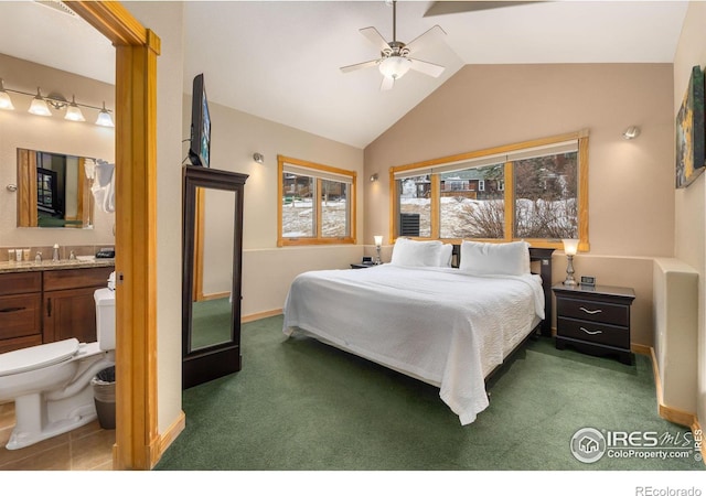 bedroom featuring lofted ceiling, sink, dark carpet, ceiling fan, and ensuite bath