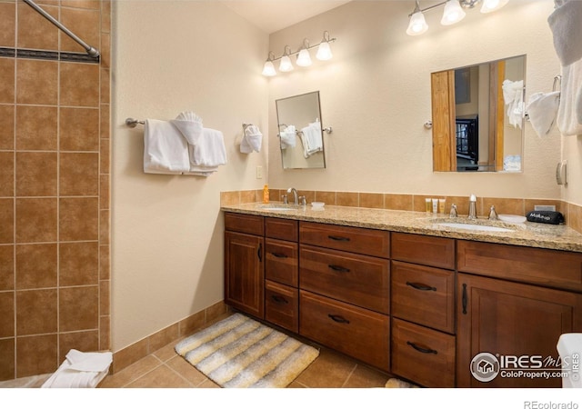 bathroom with tile patterned flooring, vanity, and a shower