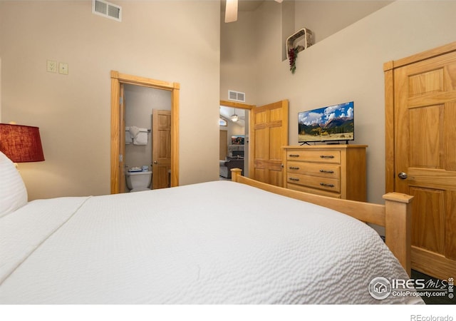 bedroom featuring connected bathroom and a high ceiling