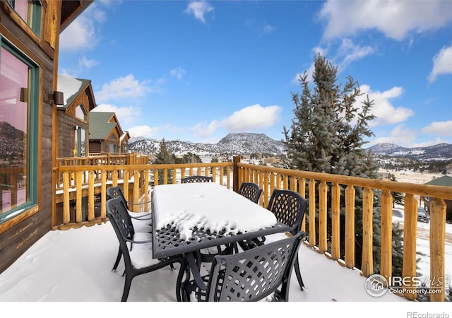 snow covered deck with a mountain view