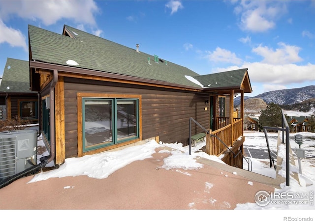 snow covered property featuring cooling unit and a mountain view