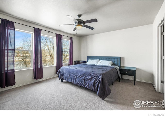 carpeted bedroom featuring a textured ceiling and ceiling fan