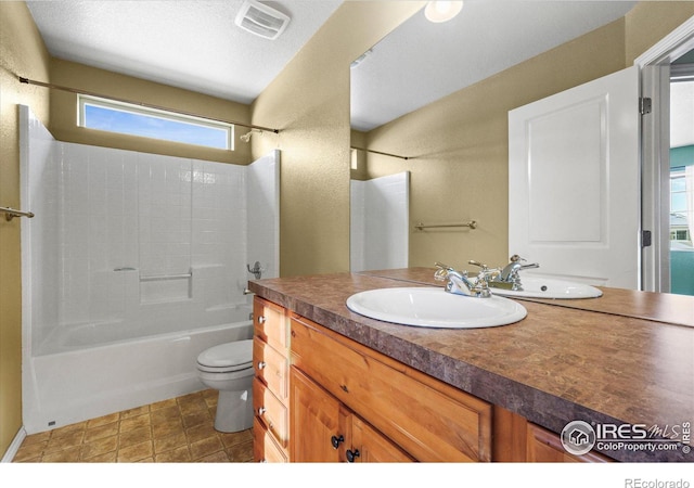 full bathroom featuring vanity, a wealth of natural light, washtub / shower combination, and toilet