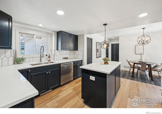 kitchen with dishwasher, a center island, sink, and decorative light fixtures