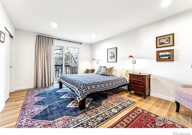 bedroom featuring wood-type flooring and access to outside