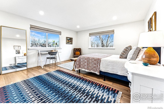 bedroom featuring multiple windows and hardwood / wood-style flooring