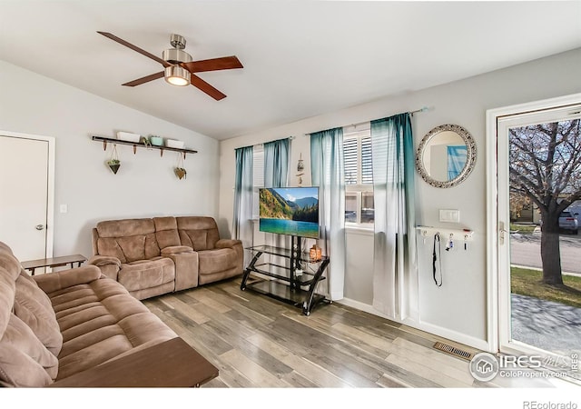 living room featuring ceiling fan, lofted ceiling, and light wood-type flooring