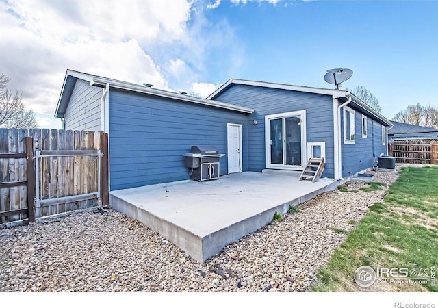 rear view of house featuring cooling unit and a patio area