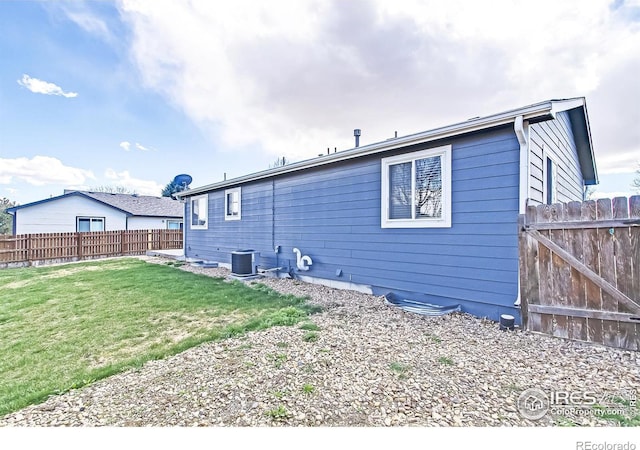 rear view of house with a yard and central AC unit