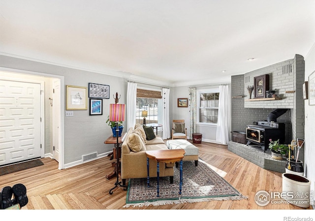 living room with crown molding and a wood stove