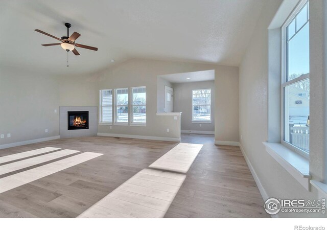 unfurnished living room featuring vaulted ceiling, ceiling fan, and light hardwood / wood-style flooring