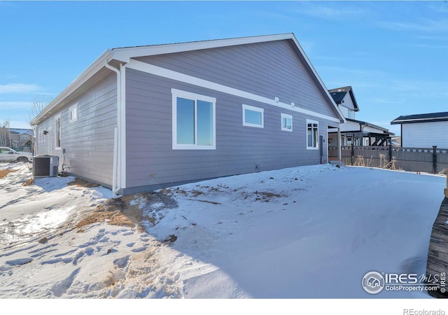 snow covered back of property with cooling unit