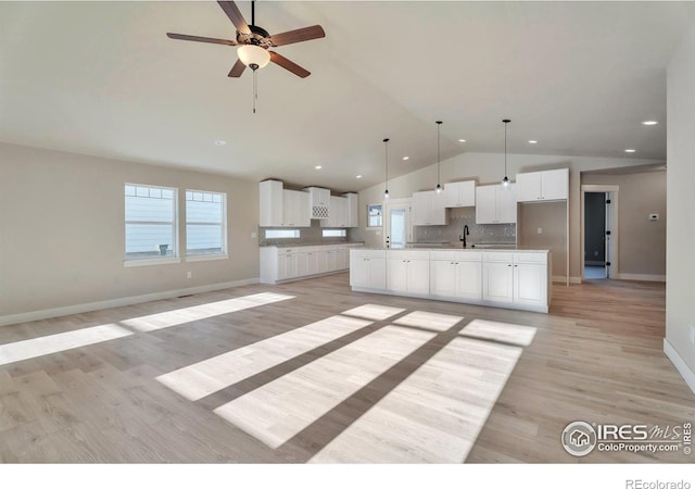 5753 Pintail Way, Frederick, CO 80504 - kitchen with lofted ceiling, a sink, open floor plan, white cabinets, and ceiling fan