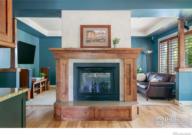 living room with light hardwood / wood-style floors and a tile fireplace