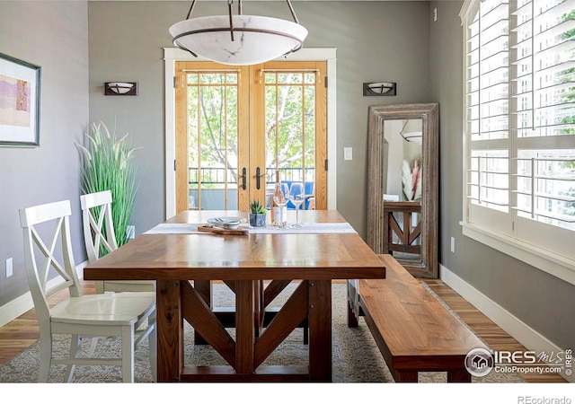 dining room with hardwood / wood-style floors and french doors