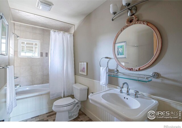 full bathroom featuring toilet, sink, tile patterned floors, and shower / bath combo with shower curtain