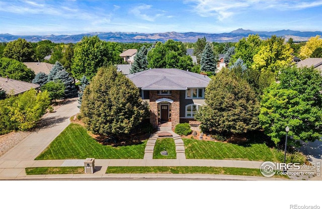 view of front of home featuring a mountain view and a front lawn