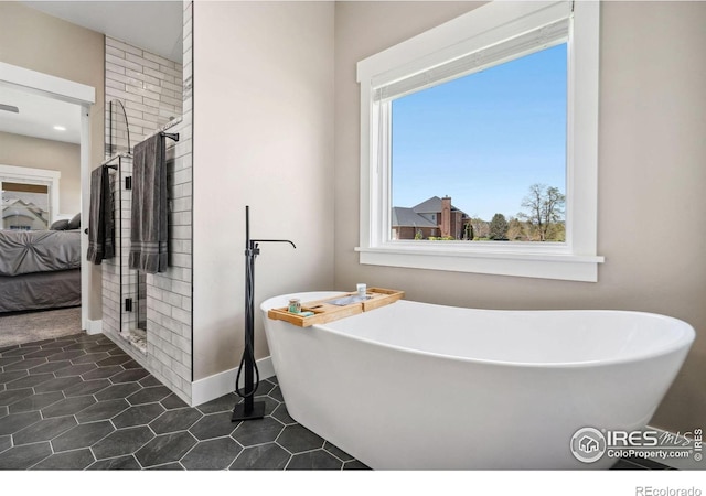 bathroom with a tub to relax in and tile patterned flooring