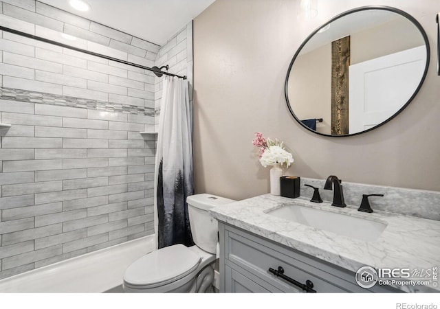 bathroom featuring vanity, toilet, and curtained shower