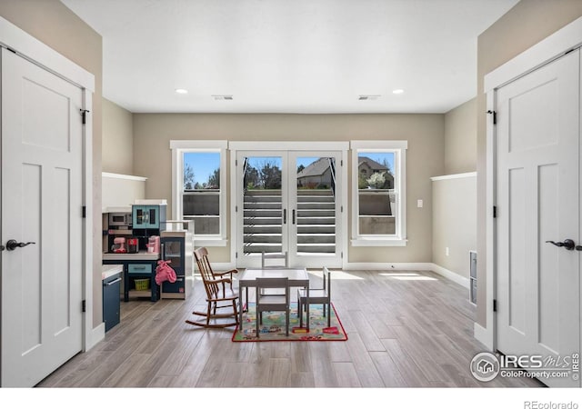 dining area with light hardwood / wood-style floors and french doors