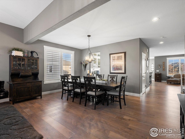 dining area with dark hardwood / wood-style flooring and a chandelier