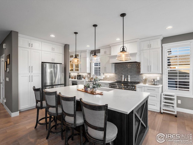 kitchen featuring white cabinetry, a center island, and stove