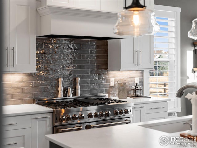 kitchen featuring white cabinetry, double oven range, decorative backsplash, and sink