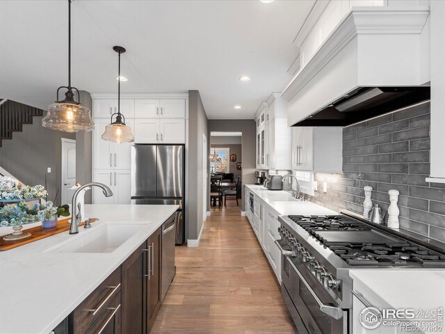 kitchen featuring sink, hanging light fixtures, white cabinets, and appliances with stainless steel finishes