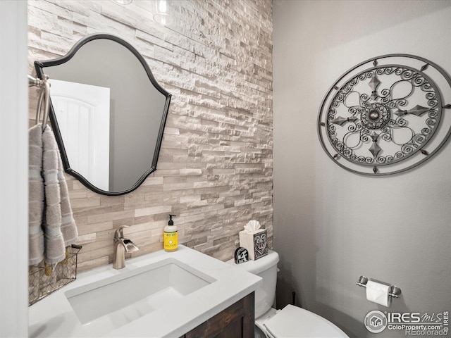 bathroom with vanity, backsplash, and toilet