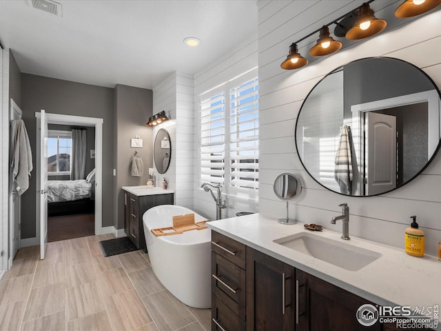 bathroom featuring vanity and a bath