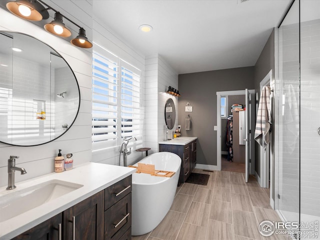 bathroom featuring vanity and independent shower and bath