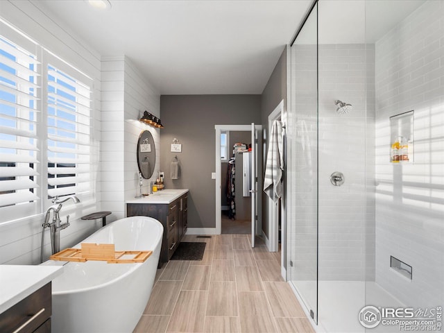 bathroom with vanity and shower with separate bathtub