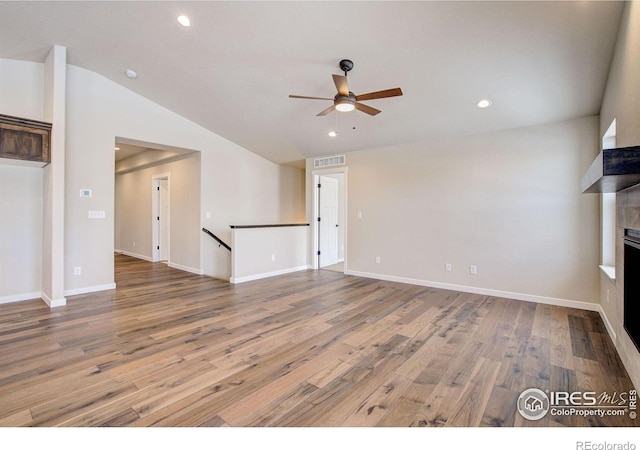 unfurnished living room with vaulted ceiling, hardwood / wood-style floors, and ceiling fan