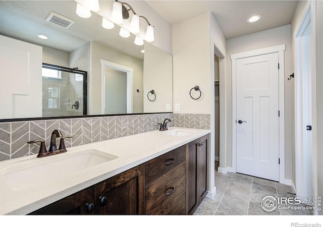 bathroom with vanity, an enclosed shower, tile patterned floors, and decorative backsplash