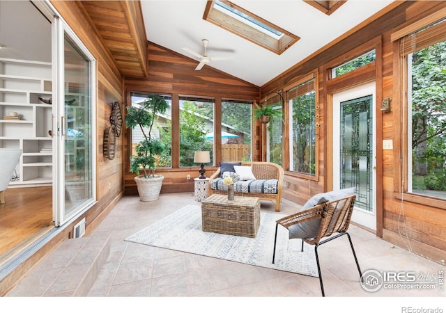 sunroom / solarium with a wealth of natural light, vaulted ceiling with skylight, and ceiling fan