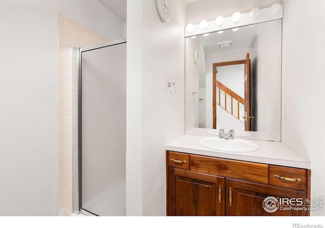 bathroom featuring vanity and a shower with shower door