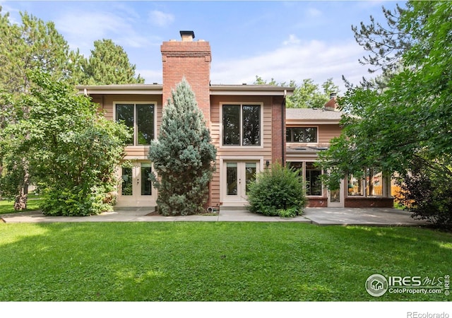 rear view of house featuring french doors, a yard, and a patio