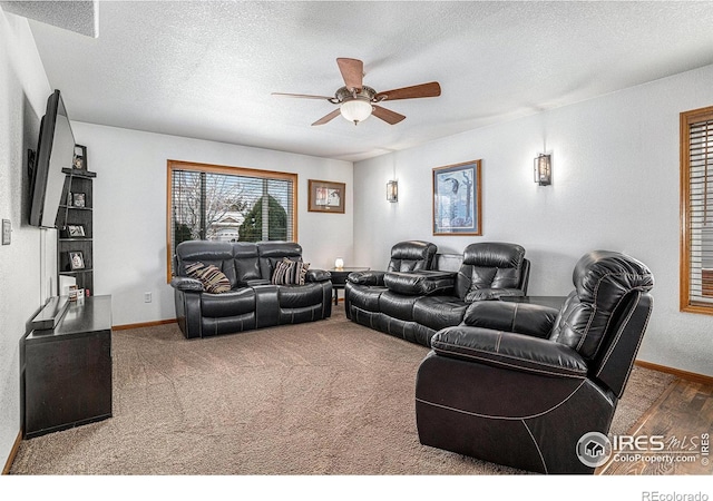 carpeted living room featuring ceiling fan and a textured ceiling