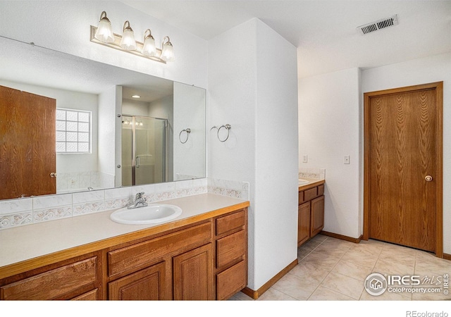 bathroom featuring vanity, tile patterned floors, and a shower with shower door