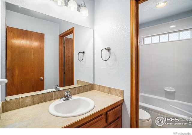 full bathroom featuring washtub / shower combination, vanity, and toilet