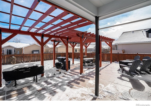 snow covered patio featuring a grill and a pergola